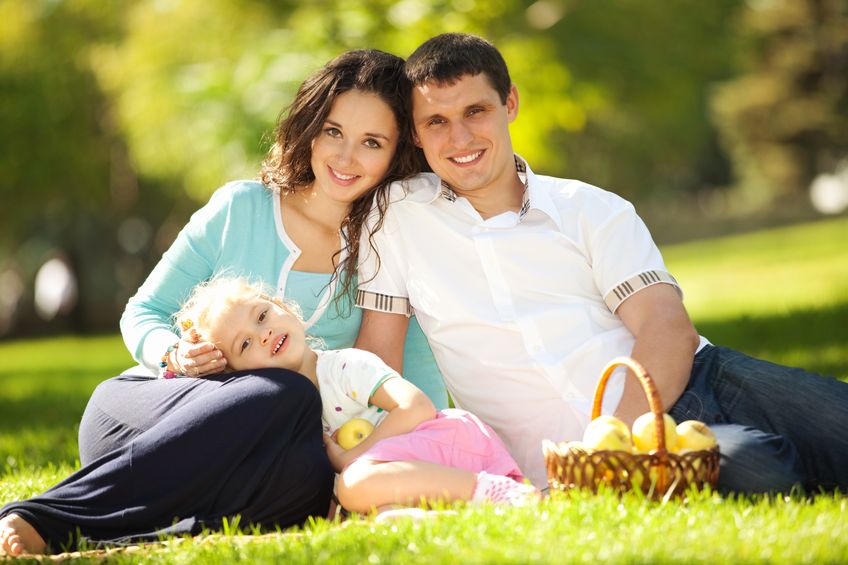 18318590 gelukkig gezin met een picknick in de groene tuin